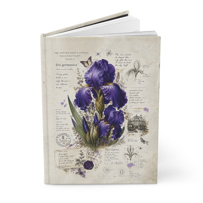 A hardcover journal featuring a vintage-style botanical illustration of purple irises on a cream-colored cover, shown standing upright against a white background.