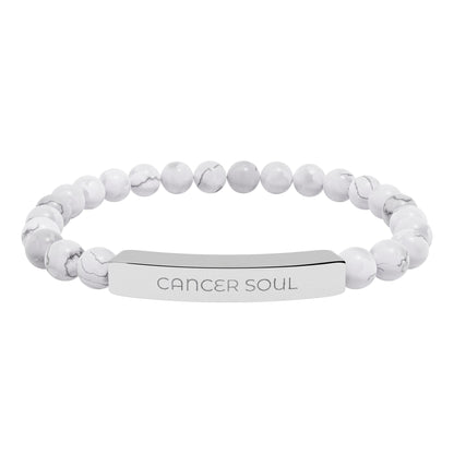 White beaded bracelet with an engraved tag on a white background