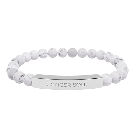 White beaded bracelet with an engraved tag on a white background