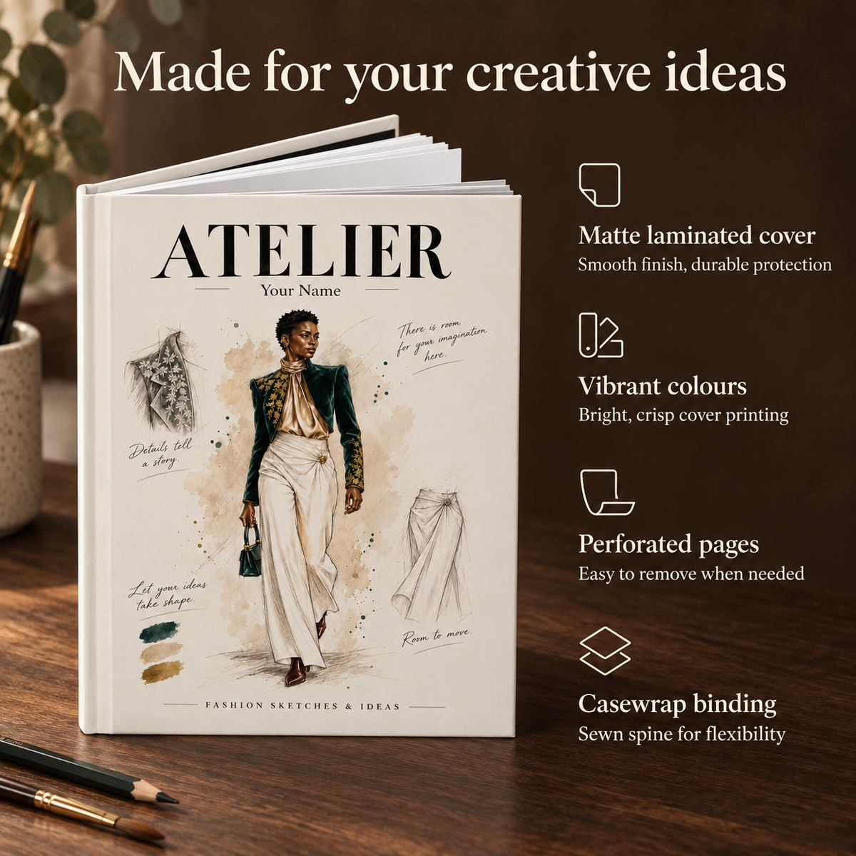 A hardcover sketchbook titled 'ATELIER' with fashion illustration artwork on the cover, displayed on a wooden surface with promotional text and feature callouts about the matte laminated cover, vibrant printing, perforated pages, and sewn spine.
